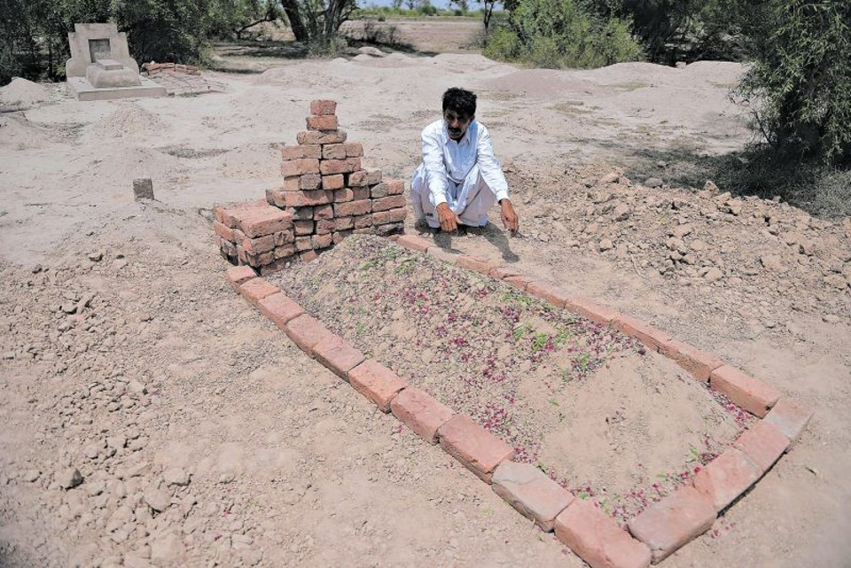 Crime de honra expõe lei deficiente Muhammad Iqbal no túmulo de sua segunda mulher, espancada até a morte por sua própria família em maio deste ano; porém, Iqbal também assassinou sua primeira esposa em 2009 | Fotos: Aamir Qureshi/Agence France-Presse Getty Images