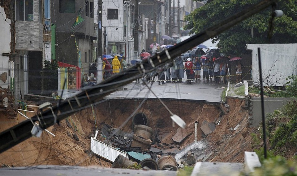 Enxurrada causou aparecimento de buraco em rua de Natal. Situação na cidade obrigou a Fifa a cancelar a Fan Fest pelo terceiro dia consecutivo | Toru Hanai / Reuters