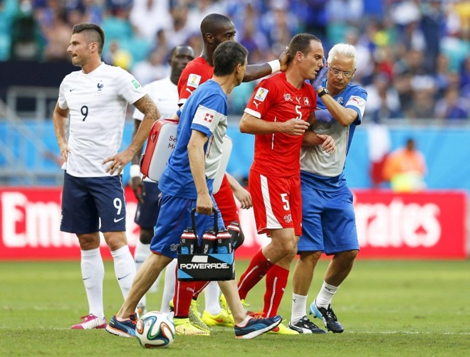 Steve von Bergen (dir.), da Suíça, deixa o jogo após ser atingido no rosto por Olivier Giroud (esq.), atacante da França |