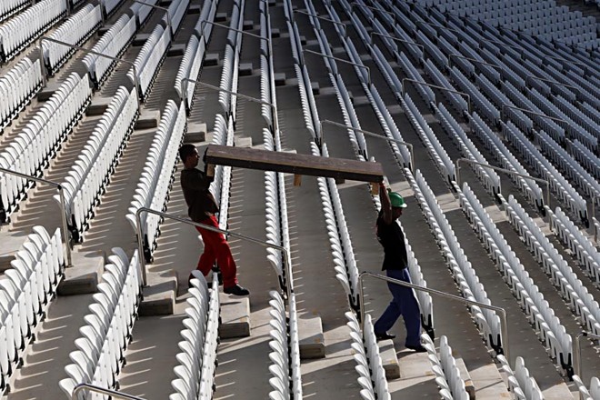 Operários levam estrutura de madeira para o gramado do Itaquerão. Sábado de muito trabalho no estádio da abertura da Copa. | 