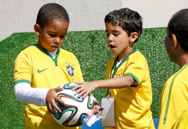 Bernardo Nascimento (à esq.), 7 anos, brinca com a Brazuka que ganhou de Neymar | 