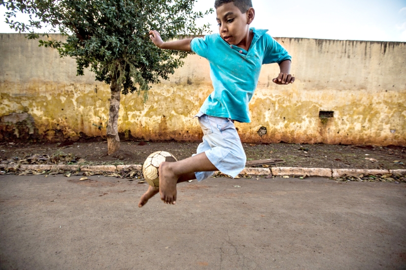 Criança joga bola na rua em Santa Amélia, Norte do estado | Brunno Covello/Gazeta do Povo