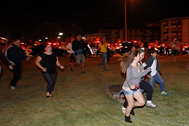 Torcedores correm pelo gramado em frente ao hotel para tentar ver os jogadores. |