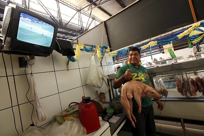 Açougueiro vê jogo da Copa pela tevê em Cuiabá. Fifa espera ultrapassar 3,2 bilhões de espectadores em 2014 | Eric Gaillard / Reuters