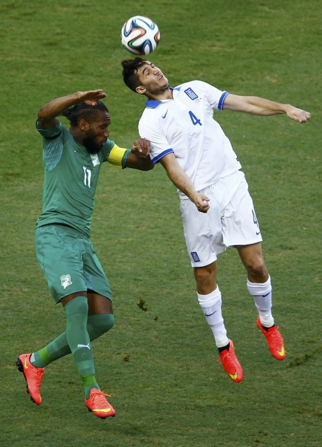 Drogba (esq.), da Costa do Marfim, em campo com o jogador grego Kostas Manolas | 