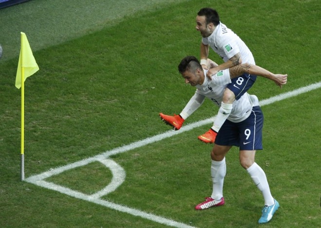 O francês Olivier Giroud carrega Mathieu Valbuena em comemoração ao terceiro gol na partida contra a Suíça |