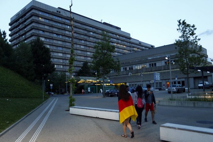 Fã do ex-piloto alemão Michael Schumacher se enrola em bandeira da Alemanha em frente ao Hospital de Lausanne, para onde o heptacampeão foi transferido | Reuters