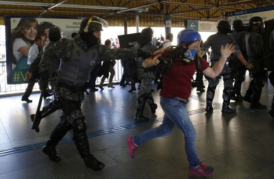 Manifestante tenta fugir da polícia na estação do metrô | Nacho Doce/ Reuters