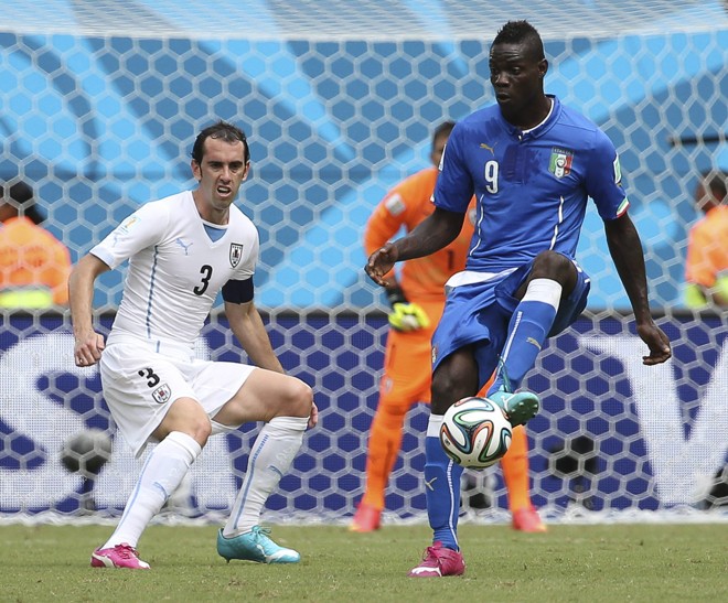 Atacante italiano Mario Balotelli (dir.) e jogador da seleção do Uruguai Diego Godin durante partida do grupo D | 