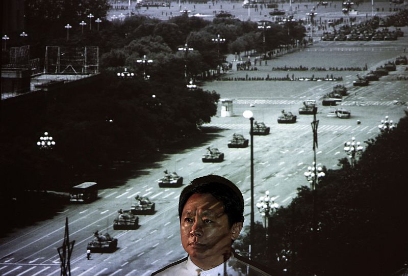 Sin Wai-Keung, editor de jornal e ex-repórter fotográfico, posa em frente a uma projeção de uma foto que tirou em Pequim em 1989. Foto de Sin mostra um homem em pé na frente de uma coluna de tanques em Pequim, na manhã de 5 de Junho de 1989. Recordando o momento em que ele tirou a foto, Sin disse: "o mais importante, ele foi fotografado. Eu não pensei sobre o perigo, ou se ele se tornaria uma imagem icônica, como a notícia ainda estava acontecendo." | REUTERS / Bobby Yip