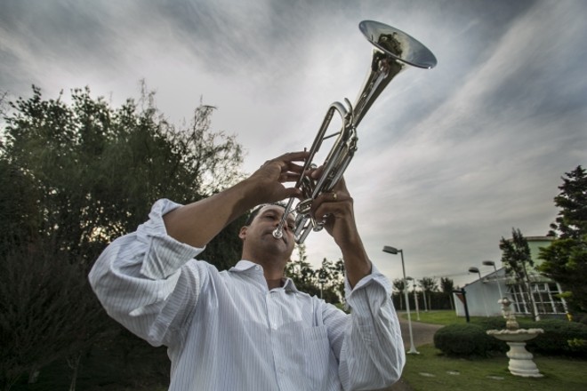 O músico Marcos Rodrigues estuda instrumento durante intervalo de aula na Vila da Cidadania | 