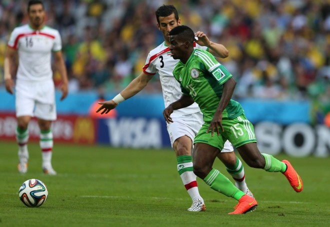 Ehsan Hajsafi, da Seleção Iraniana, compete pela posse de bola contra Ramon Azeez, da Nigéria, em partida na Arena da Baixada |