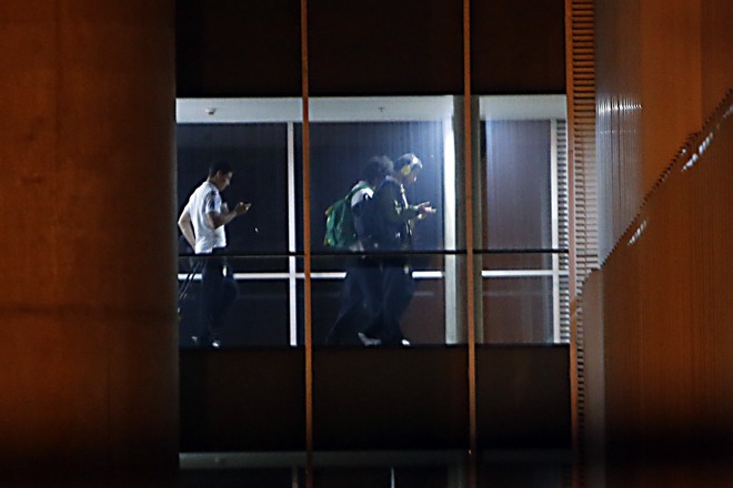 Hernanes, Marcelo e Fred checam seus telefones celulares na chegada ao hotel. |