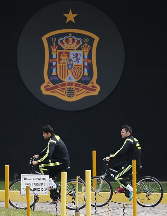 Diego Costa e Fábregas aproveitam as bicicletas para fazer aquecimento para treino |
