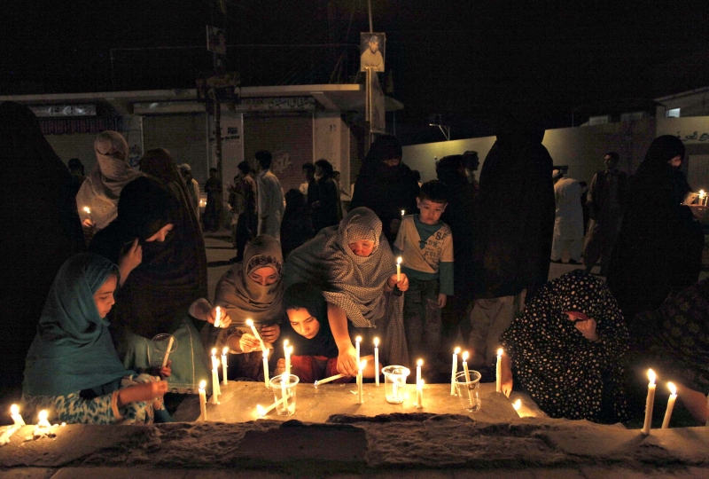 Mulheres e crianças acendem velas em funeral no Paquistão | Naseer Ahmed/Reuters