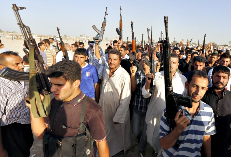 Voluntários do exército iraquiano para lutar contra militantes sunitas carregam armas durante uma parada em Bagdá | Thaier Al-Sudani/Reuters