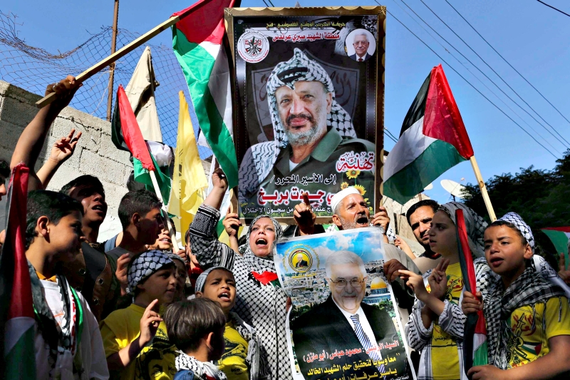 Palestinos comemoram nova fase com fotos de Yasser Arafat e do presidente Mahmoud Abbas | Ibraheem Abu Mustafa/Reuters