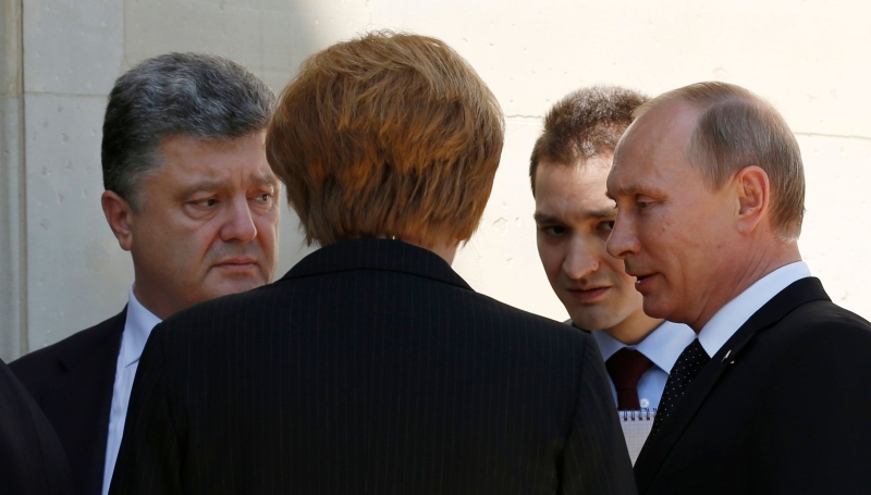 Petro Poroshenko (à esquerda) teve encontro com Vladimir Putin, intermediado por Angela Merkel (de costas) | Kevin Lamarque /Reuters
