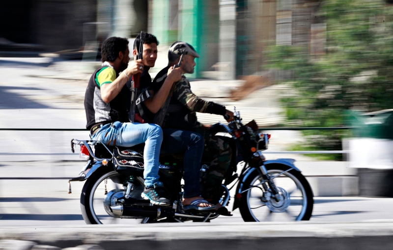 Rebeldes do Exército Livre da Síria transitam pelas ruas de Aleppo; governo de Assad vai conceder perdão aos que não cometeram crimes envolvendo mortes | Nour Kelze/Reuters