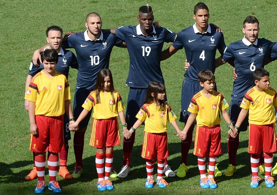 Baixinho Valbuena praticamente some atrás do maior dos mascotes da Fifa durante a execução dos hinos nacionais em Alemanha 1 x 0 França | EFE