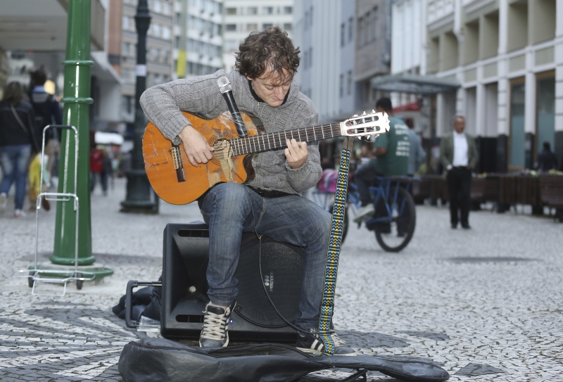 Emiliano Ernesto Charly em seu palco improvisado no calçadão da Rua XV: o músico dorme no carro e chega a ganhar até R$ 300 por dia | Giuliano Gomes/Gazeta do Povo