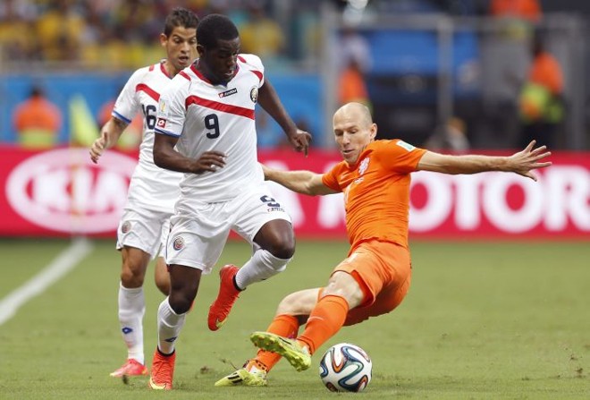 Costarriquenho Joel Campbell tenta passar pela marcação do holandês Robben |