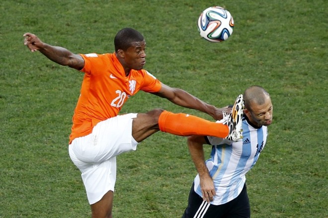 O meia Georginio Wijnaldum compete com o argentino Mascherano | 