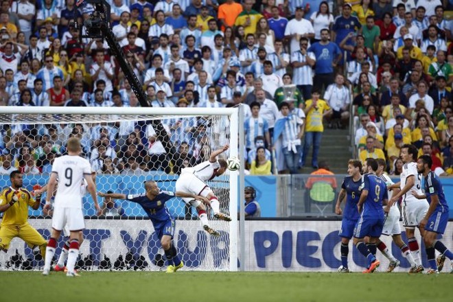 O zagueiro alemão Hoewedes cabeceira e a bola acerta a trave argentina | 