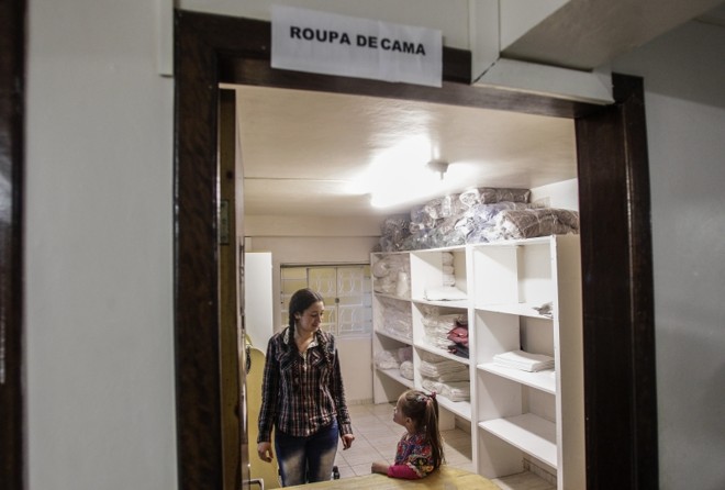 Funcionária e paciente trajados para festa junina, na sala onde se guardam as roupas de cama. Mais de 50 funcionários mantêm a rotina da Casa de Apoio Ideal |