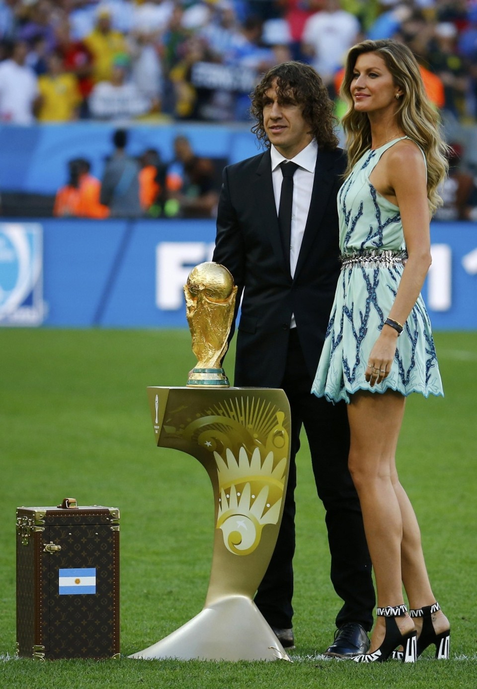 Gisele Bündchen
(ao lado do craque espanhol Puyol) e a colombiana Shakira foram as melhores em campo ontem, tirando a performance das duas seleções finalistas. A maleta Louis Vuitton, que guardava a taça do mundo, também não passou despercebida. Tem tudo para virar objeto de desejo | Kai Pfaffenbach/Reuters