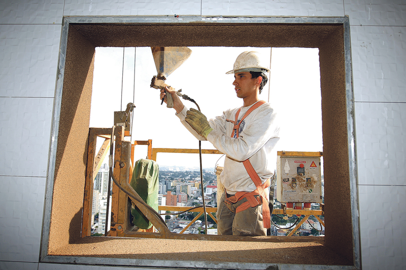 Construtora Laguna: pintura externa utiliza jateamento de textura feito com a ajuda de  uma pistola | Ivonaldo Alexandre/Gazeta do Povo