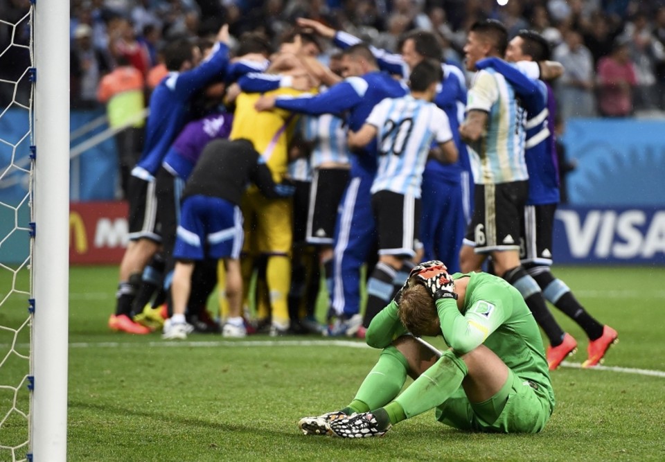 O goleiro Cillessen, que nunca pegou um pênalti na carreira, se lamenta no gramado enquanto os argentinos comemoram | Dylan Martinez/ Reuters