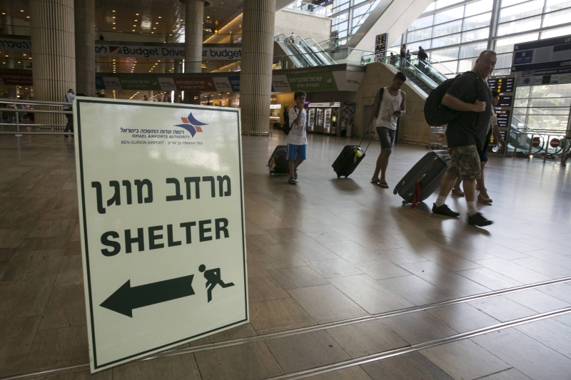 Passageiros passam por sinal no aeroporto de Ben Gurion, em Tel Aviv, indicando um abrigo antibombas: na última quinta-feira, os EUA suspenderam a proibição de voos com destino a Israel | Baz Ratner/Reuters