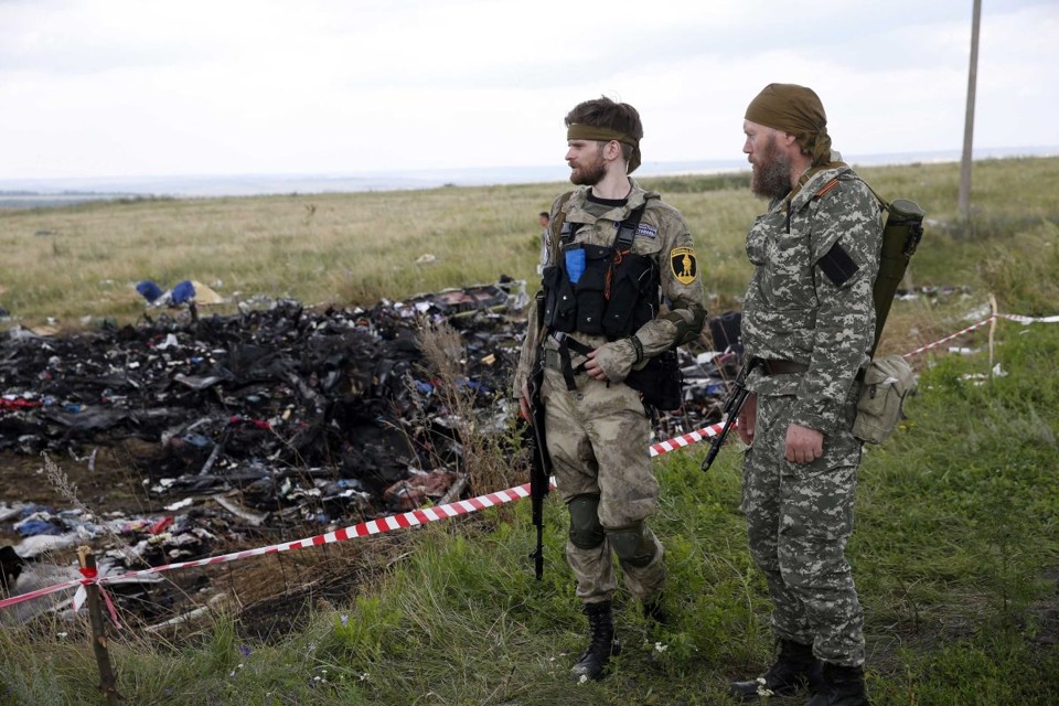 Rebeldes russos monitoram o local onde caiu o avião. O grupo recebeu críticas por ter alterado a área dos destroços | REUTERS/Maxim Zmeyev