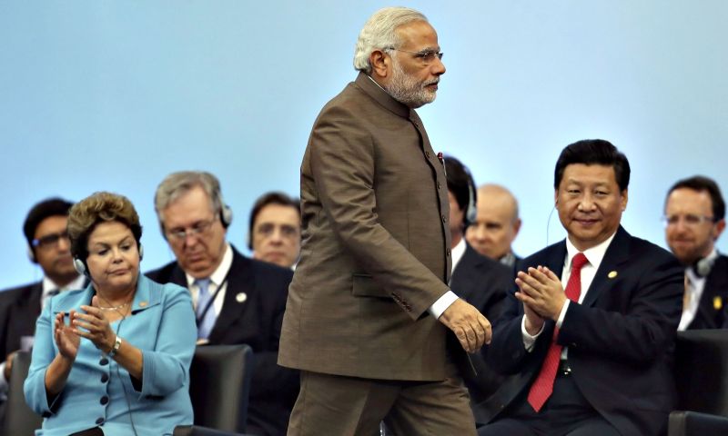 O primeiro ministro da Índia, Narendra Modi (em pé, observado por Dilma Rousseff e o presidente chinês Xi Jinping), não conseguiu emplacar Nova Déli como sede do banco, mas ficou satisfeito com a presidência do órgão | Nacho Doce/Reuters