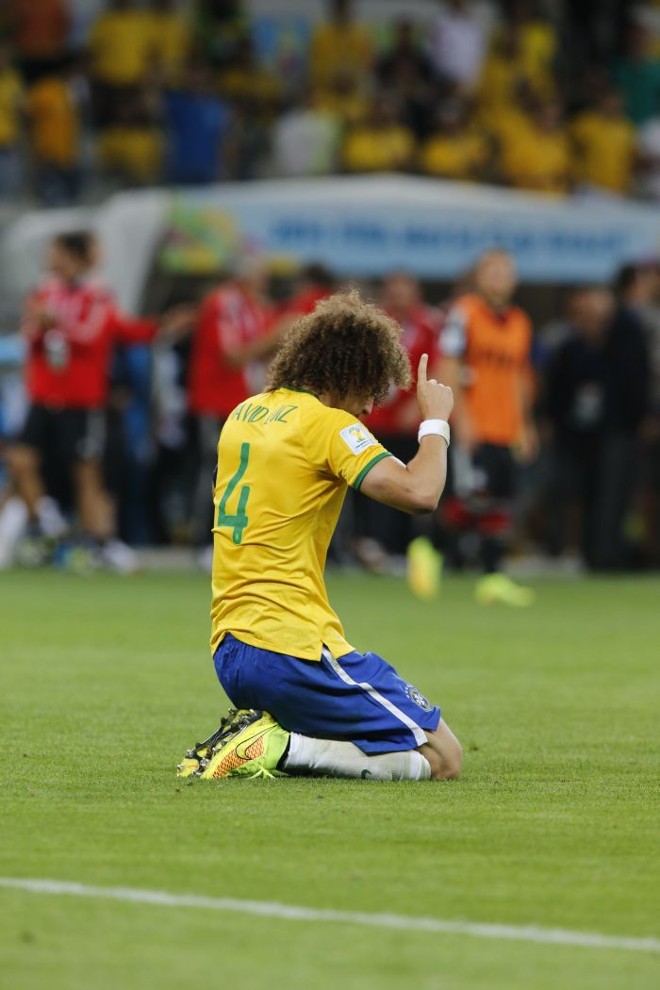 O zagueiro David Luiz, que atuou como capitão da seleção, se ajoelha em capo após derrota | 