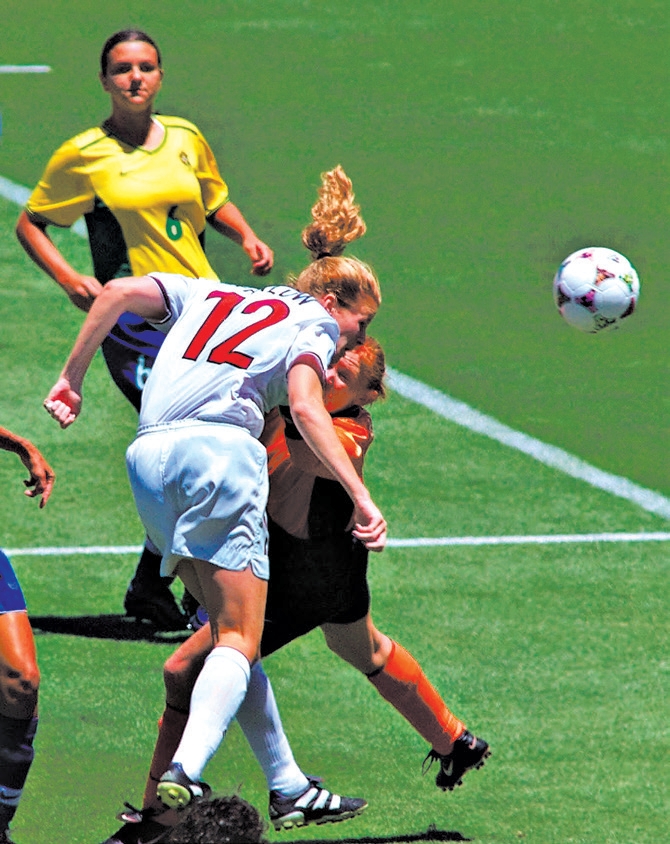 Cindy Parlow cabeceando a bola para o gol na Copa do Mundo de Futebol Feminino em 1999 | Eric Risberg/Associated Press