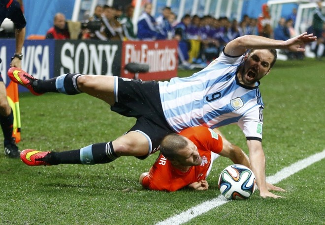 O argentino Gonzalo Higuain cai sobre Ron Vlaar em campo da Arena Corinthians | 