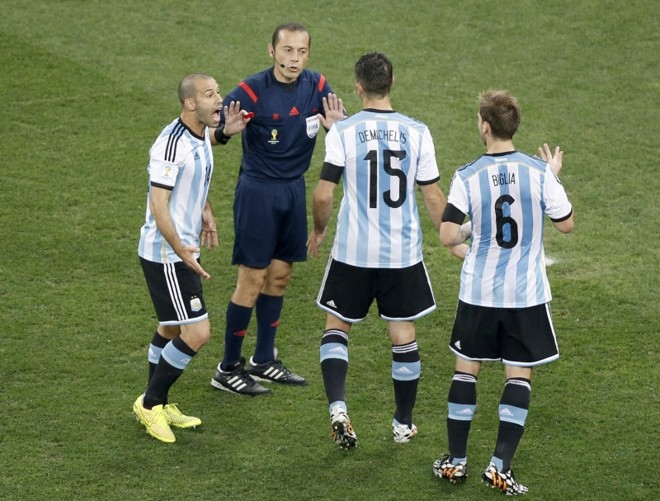 O árbitro turco Cuneyt Cakir conversa com jogadores da Argentina | 