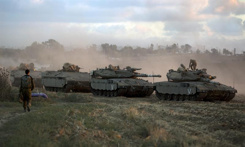 Veículos blindados israelenses retornam após manobras em uma área do sul de Israel. Os militares israelenses disseram as suas forças encontraram treze túneis na Faixa de Gaza | EFE/Jim Hollander