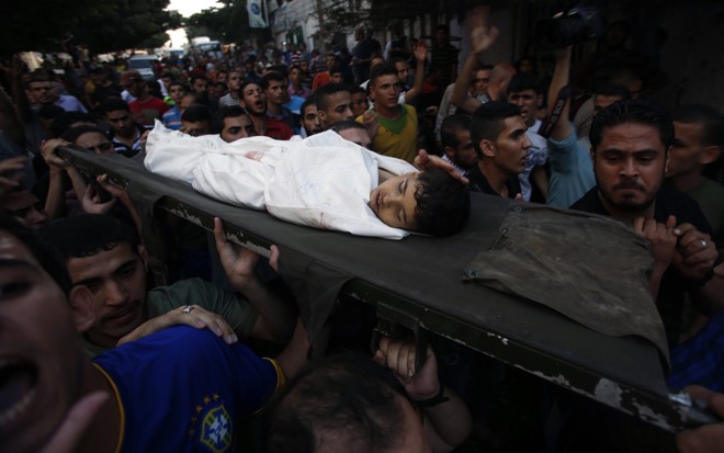 Criança atingida em bombardeio em Gaza é carregada por populares | Mohammed Salem / Reuters