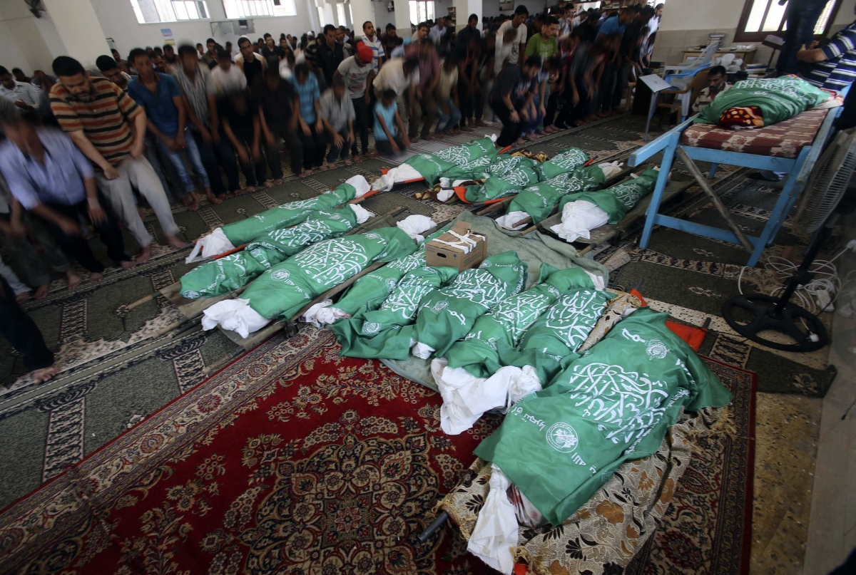 Palestinos rezam durante o funeral de uma família morta durante bombardeios israelenses no domingo (20), na Faixa de Gaza | Reuters/Ibraheem Abu Mustafa