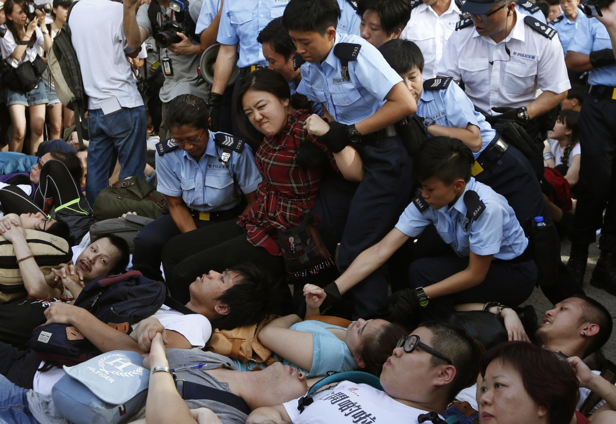 Jovem tenta se livrar enquanto é arrastada por policial feminina durante o protesto em Hong Kong | Reuters/Bobby Yip