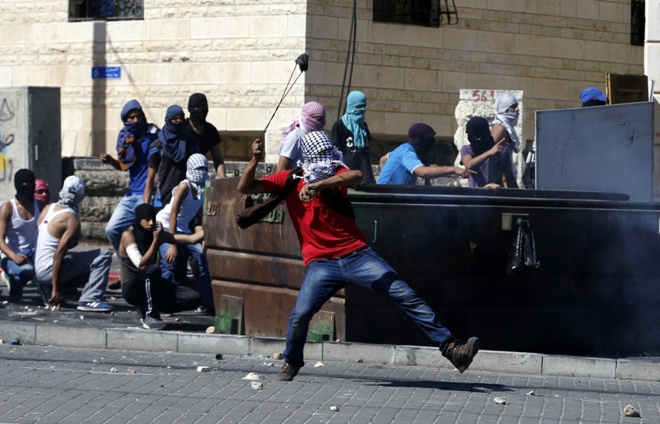 Palestino atira pedras contra policiais israelenses após a descoberta do corpo de um menino que teria sido morto por vingança | Reuters/Baz Ratner