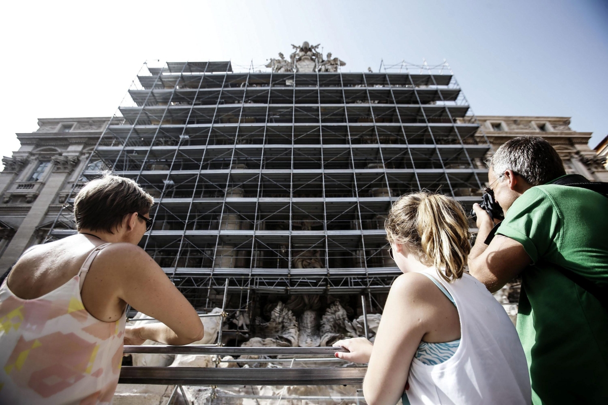 Turistas observam as obras de restauração do monumento, em Roma | EFE/Angelo Carconi