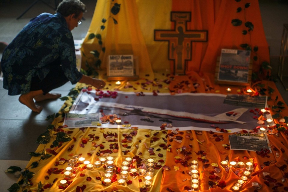 Mulher deposita pétalas de rosas no memorial feito no aeroporto de Kuala Lampur para as vítimas do voo MH17 | Reuters/Athit Perawongmetha