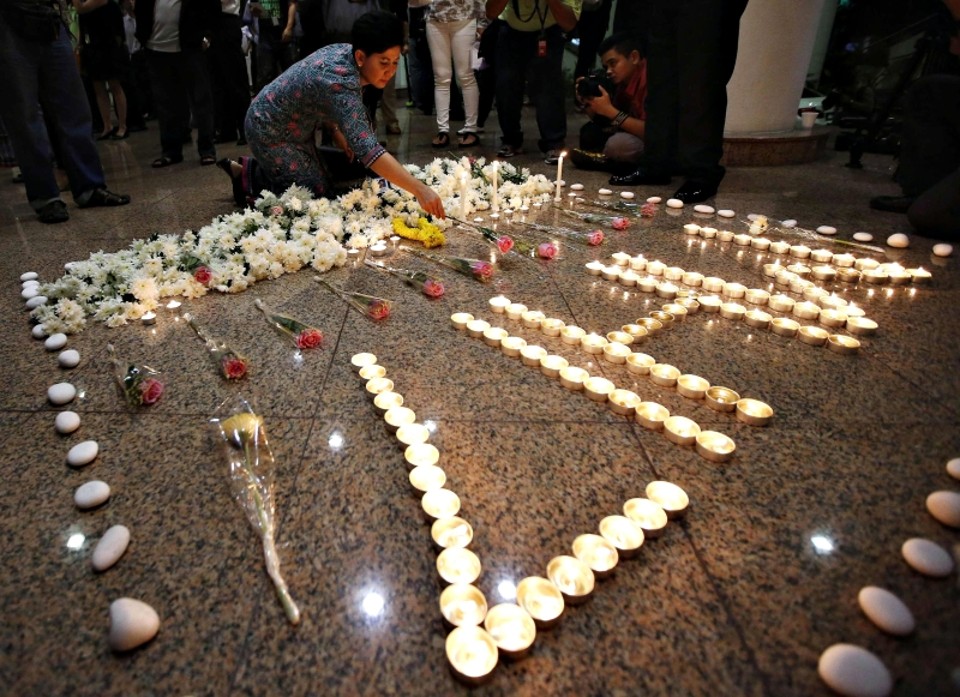Aeromoça da Malaysia Airlines coloca flor em memorial ao MH17 | Olivia Harris/Reuters