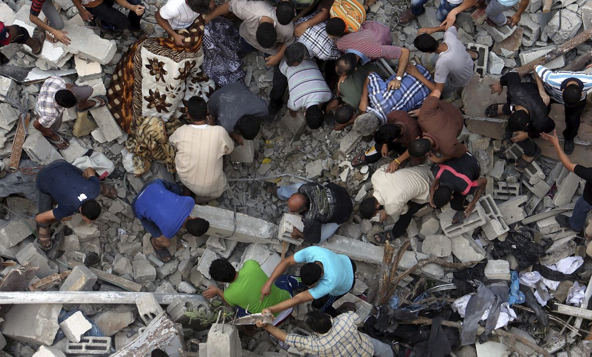 Moradores inspecionam uma casa destruída na Faixa de Gaza. Pelo menos 540 palestinos morreram nas últimas duas semanas | EFE/Mohammed Saber