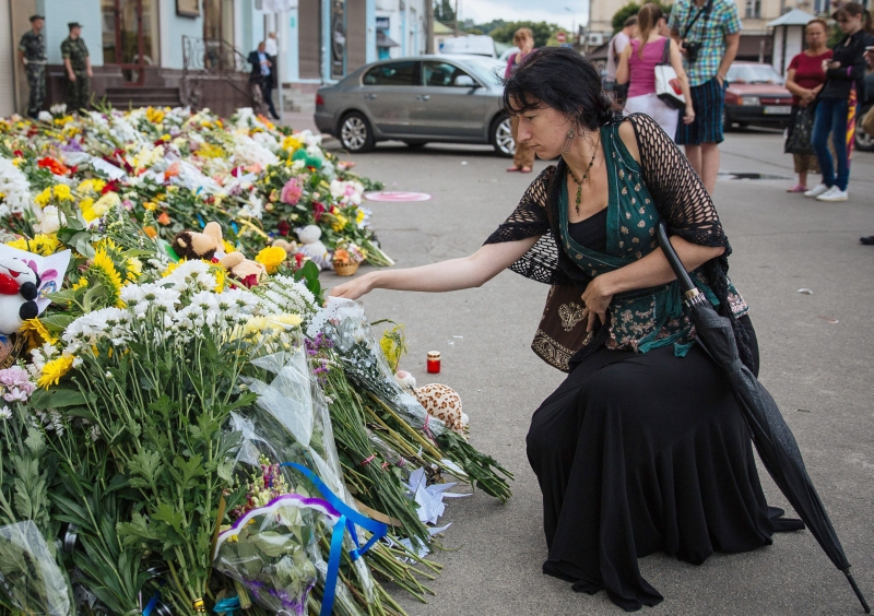 Mulher homenageia mortos do voo MH17 da Malaysia Airlines lem Kiev | EFE / Roman Pilipey