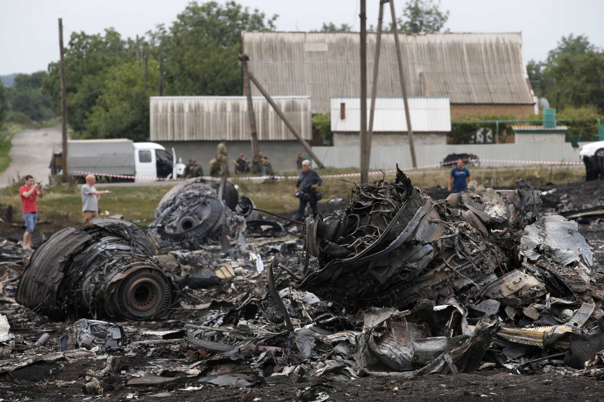 Habitantes do assentamento de Grabovo, na região de Donetsk, tiram fotos dos destroços do Boeing 777 que fazia o voo MH17 da Malaysia Airlines | Reuters/Maxim Zmeyev